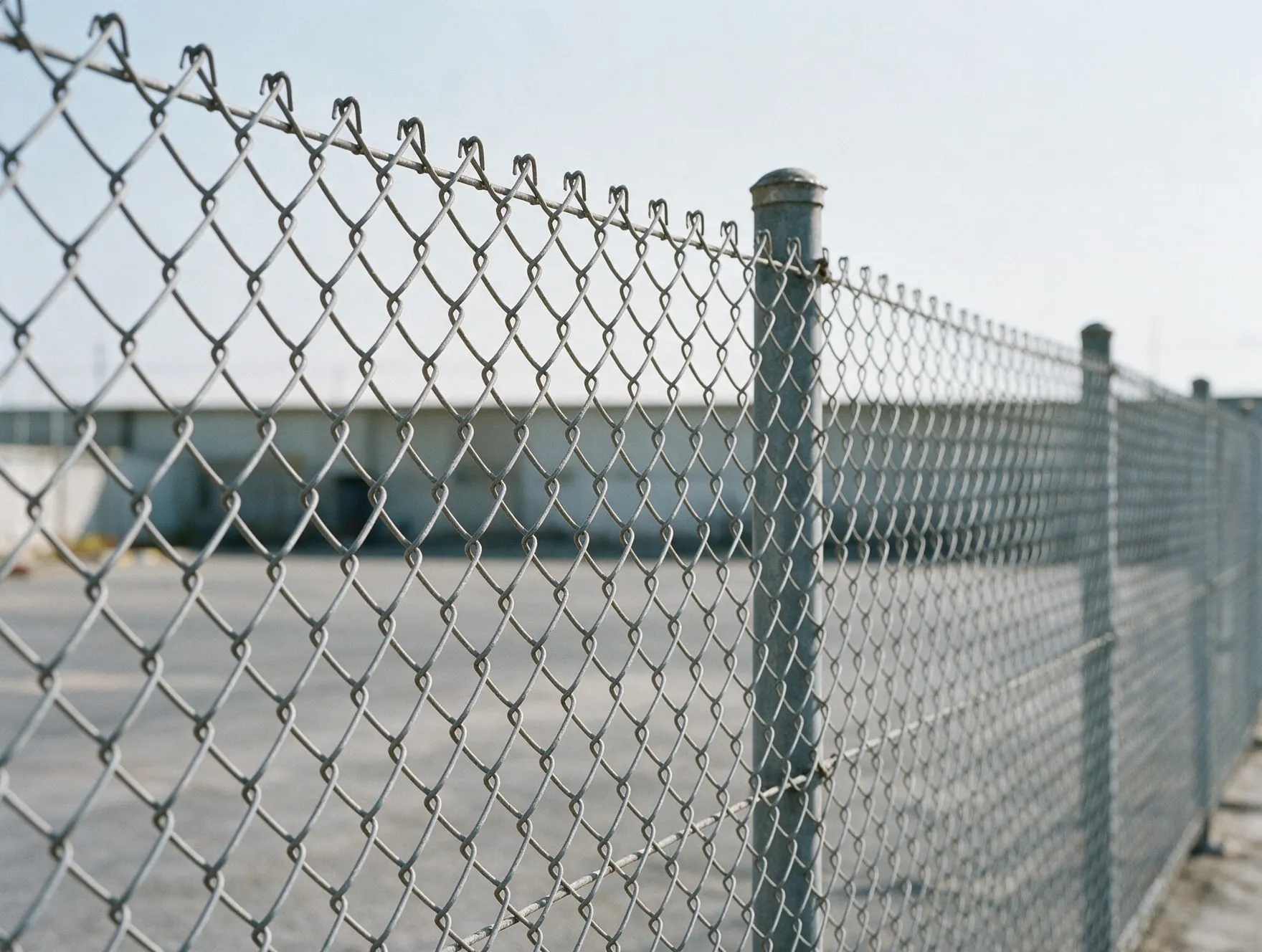 A galvanised chain link fence along the edge of an industrial compound