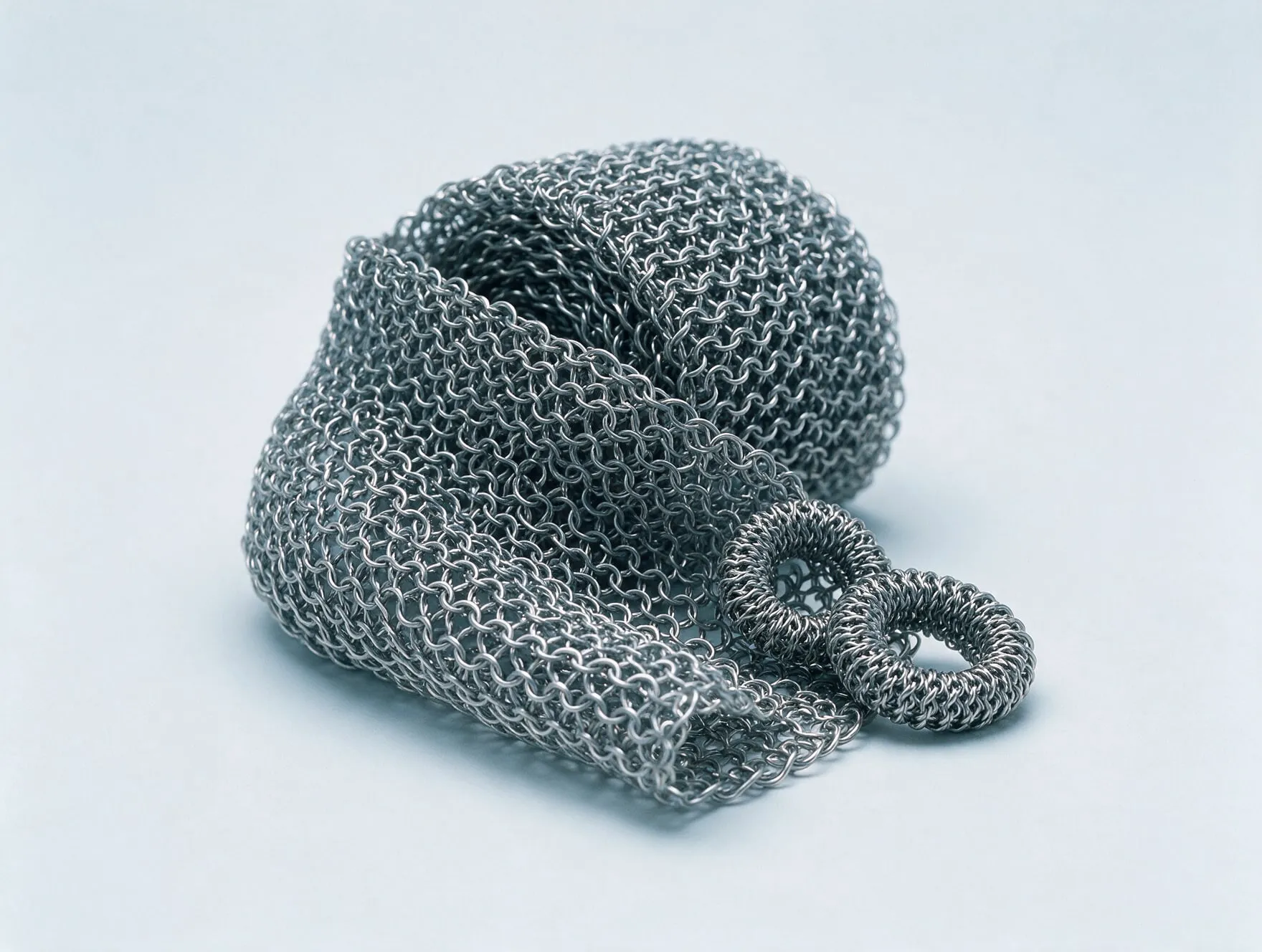 A roll of knitted stainless steel wire mesh with two compressed mesh rings