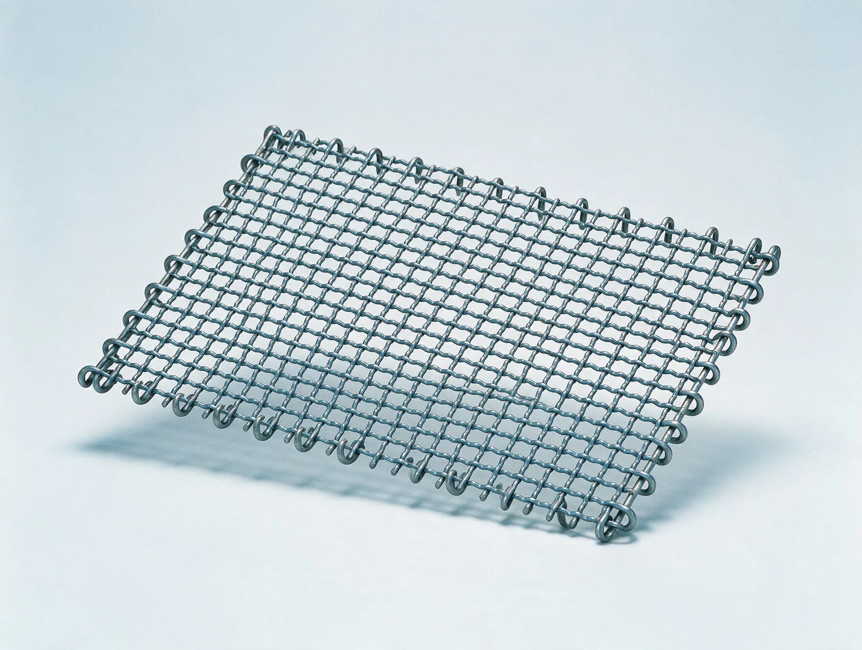 A woven wire vibrating screen panel with hooked edges